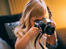 Photo of a young child aiming a camera