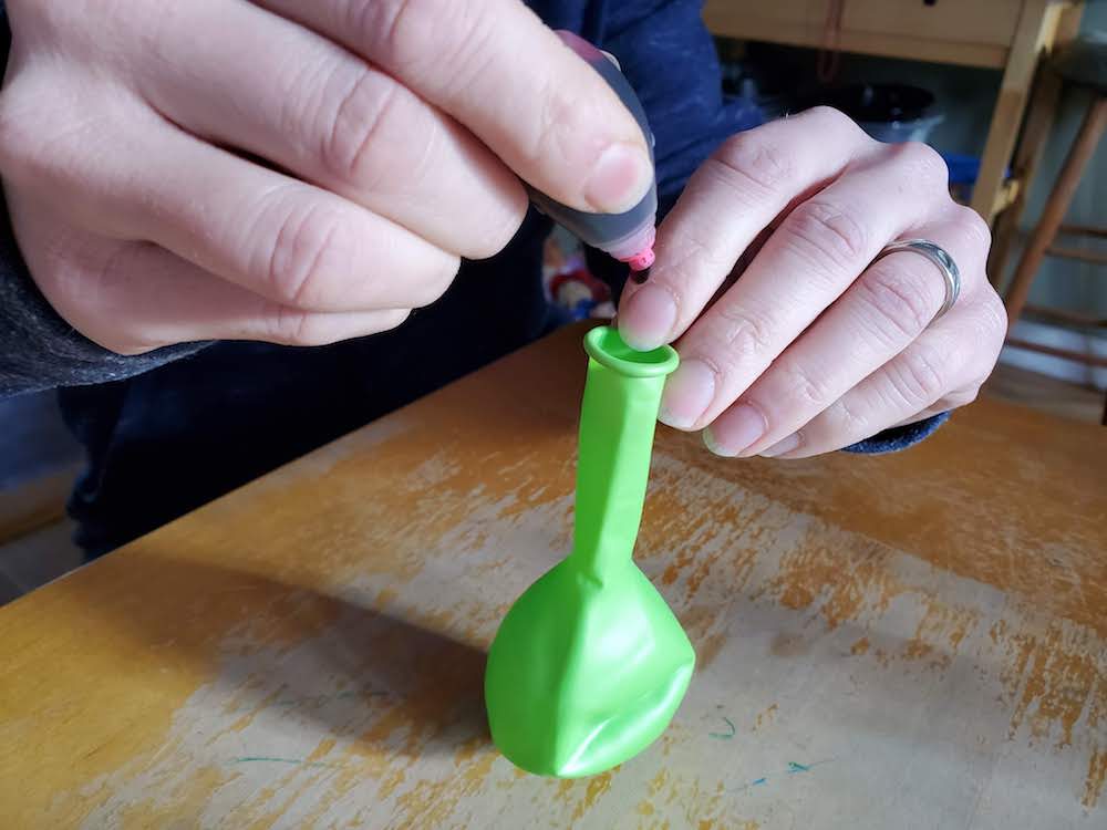 image of parent adding food coloring to a balloon