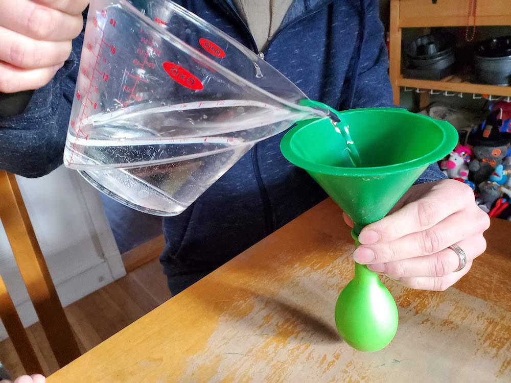 image of a parent adding water to a balloon