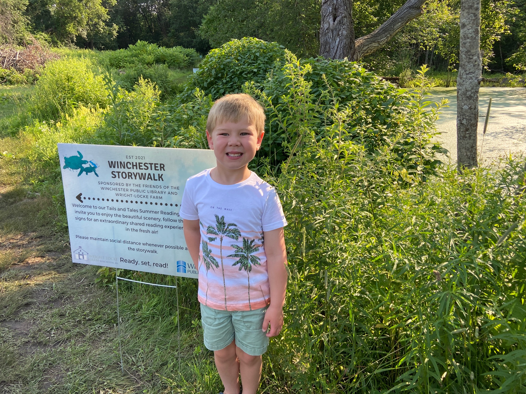 photo of child with WPL storywalk sign